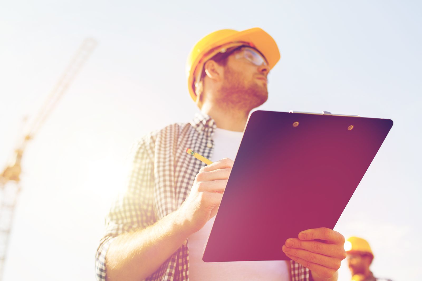Contractor with a clipboard in front of a house
